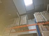 boxes are stacked on a pallet in a warehouse with a skylight above them