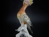 a figurine of a bird sitting on top of a branch