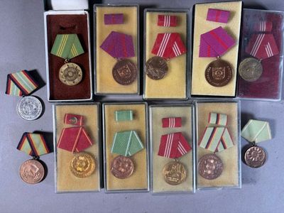 many medals and medals in small boxes on the table
