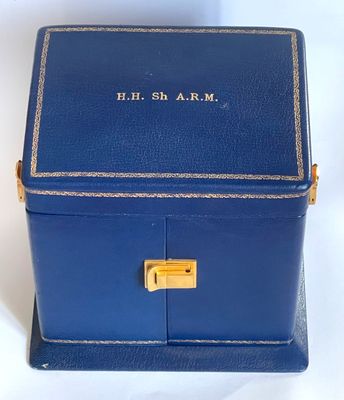 an old blue box with a brass lock on a white surface