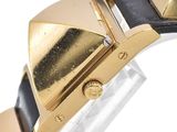 a close up of a gold and black watch on a white surface
