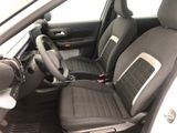 the interior of a small car with black seats and a steering wheel