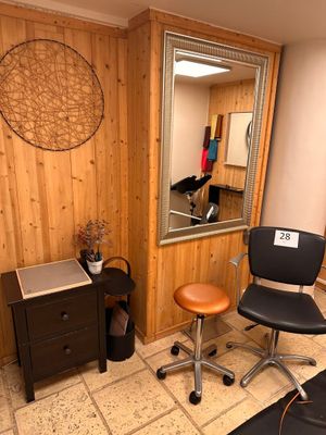 a desk with a chair and a mirror in a room