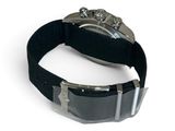 a watch that is on a black strap on a white surface