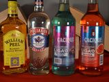 several bottles of alcohol are lined up on a red table