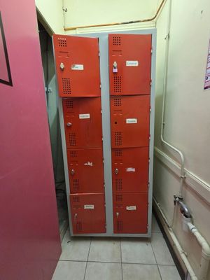 deux casiers dans le couloir d'un immeuble dont la porte est rose