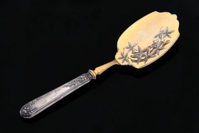a spoon with a design on it sitting on a black surface