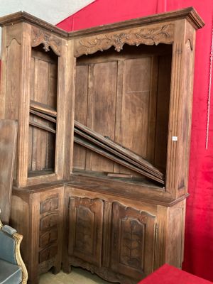 une grande armoire en bois derrière laquelle se trouve un rideau rouge