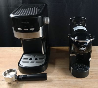 a black coffee maker and a silver coffee cup on a wooden table