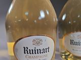 two bottles of wine sitting on top of a table next to each other