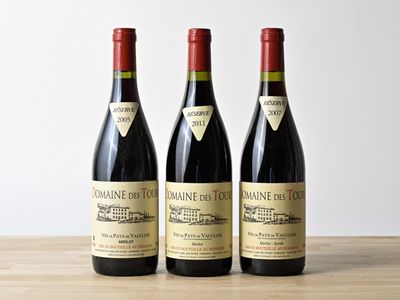 trois bouteilles de vin posées sur une table en bois