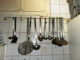 many spoons hanging from the ceiling of a kitchen