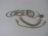 de nombreux bracelets en argent posés sur une surface blanche