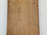 an old wooden cutting board on a white surface