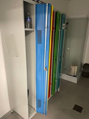 brightly colored lockers line the walls of a bathroom with a shower