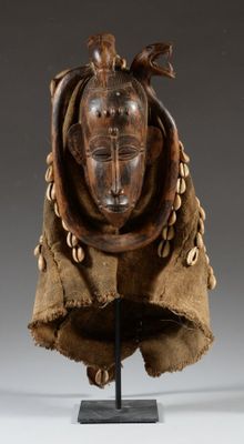 a close up of a wooden mask on a stand