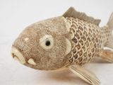 a close up of a fish figurine on a white surface