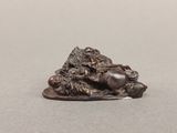 statue d'un lion posé sur un rocher, sur un fond gris