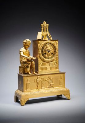 a gold clock with a statue on top of it