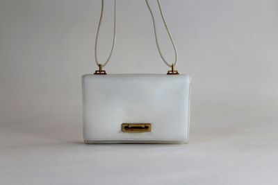 sac à main blanc avec des finitions dorées et une bandoulière en chaîne