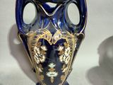 a blue vase with a gold decoration on it