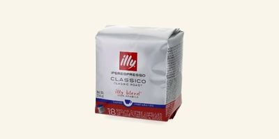 Le sachet de café est blanc et porte une étiquette rouge.