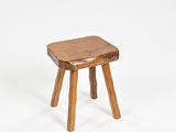 un petit tabouret en bois posé sur une surface blanche