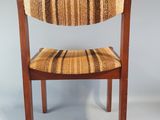 the back of a wooden chair with a striped seat and back