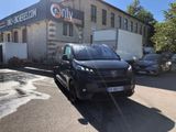 a small black van parked in front of a building