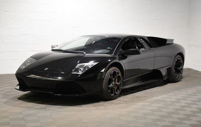 une photo d'une voiture de sport noire garée dans un garage