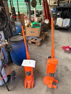 deux crics orange placés l'un à côté de l'autre dans un garage