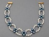 un collier de perles à trois rangs muni d'un fermoir en or