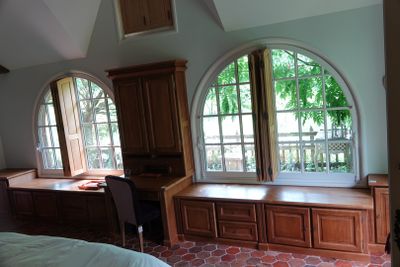 une chambre avec un lit, un bureau et des fenêtres