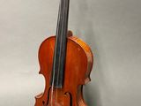 an old violin sitting on top of a table next to a gray background