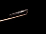 a small metal object with a wooden handle on a black background