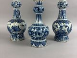 trois vases bleus et blancs posés les uns à côté des autres sur une table
