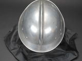 a silver helmet on a black cloth on a black surface