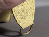 someone is holding a yellow leather keychain with a heart on it