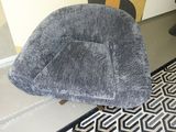 a grey chair that is sitting on a black and white rug