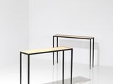deux tables dans une pièce aux murs blancs et au sol blanc