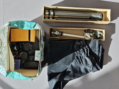 une boîte contenant un appareil photo, un trépied et d'autres objets