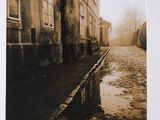 a black and white photo of a street with a puddle of water