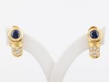 pair of sapphire and diamond earrings on a white stand