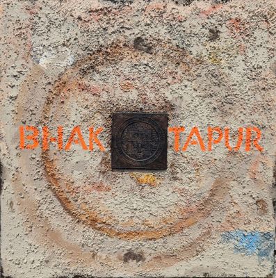 une pancarte accrochée au mur sur laquelle on peut lire « Bhak Tapur »