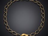 a gold necklace on a black background