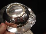 a person holding a silver plate with a silver bowl on it