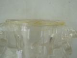 a clear glass vase with a yellow lid on a table