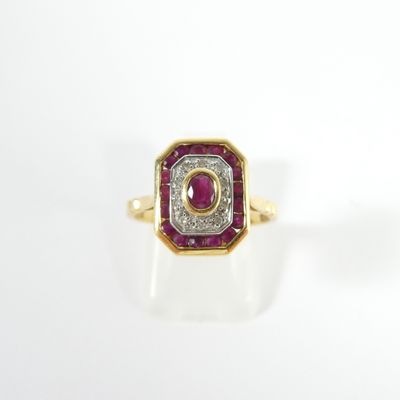 gros plan d'une bague en or avec un rubis et un diamant au centre