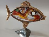 sculpture représentant un poisson sur un socle, avec un fond blanc