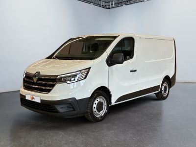 La camionnette blanche est garée dans une grande pièce équipée d'un ventilateur de plafond.